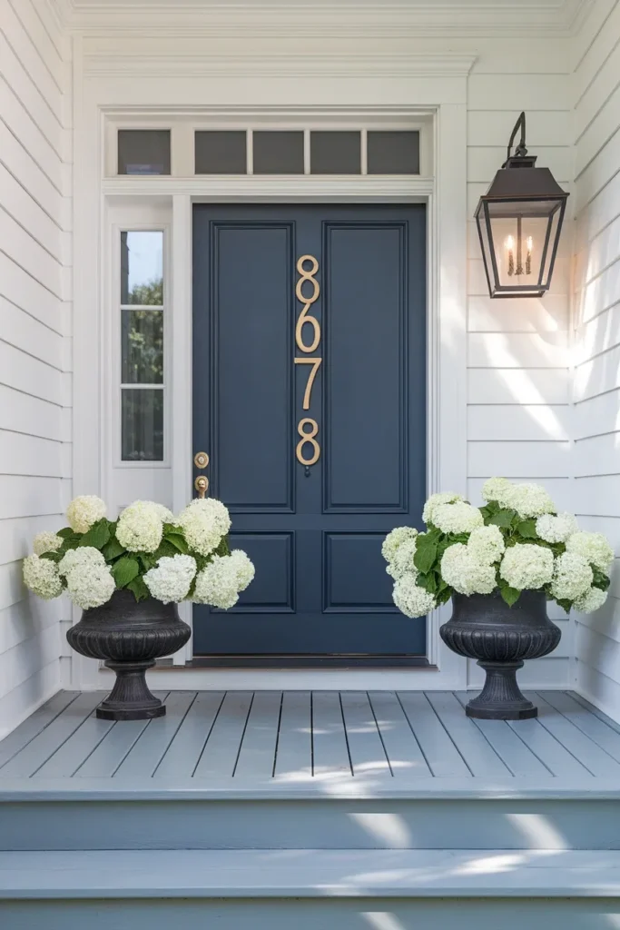 Curb appeal front entry with painted navy door, oversized house numbers and matched planters