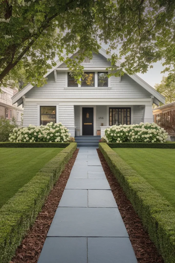 Front yard landscaping ideas for curb appeal on a gray craftsman home with deep foundation beds