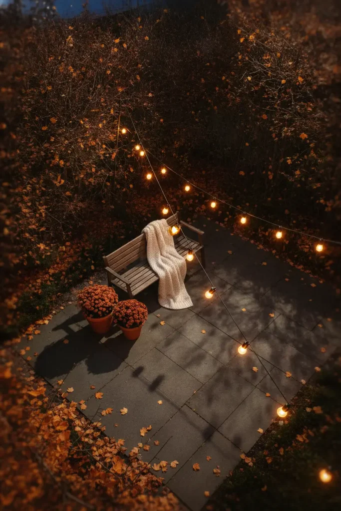 Backyard string lights glowing over a patio on a late fall evening