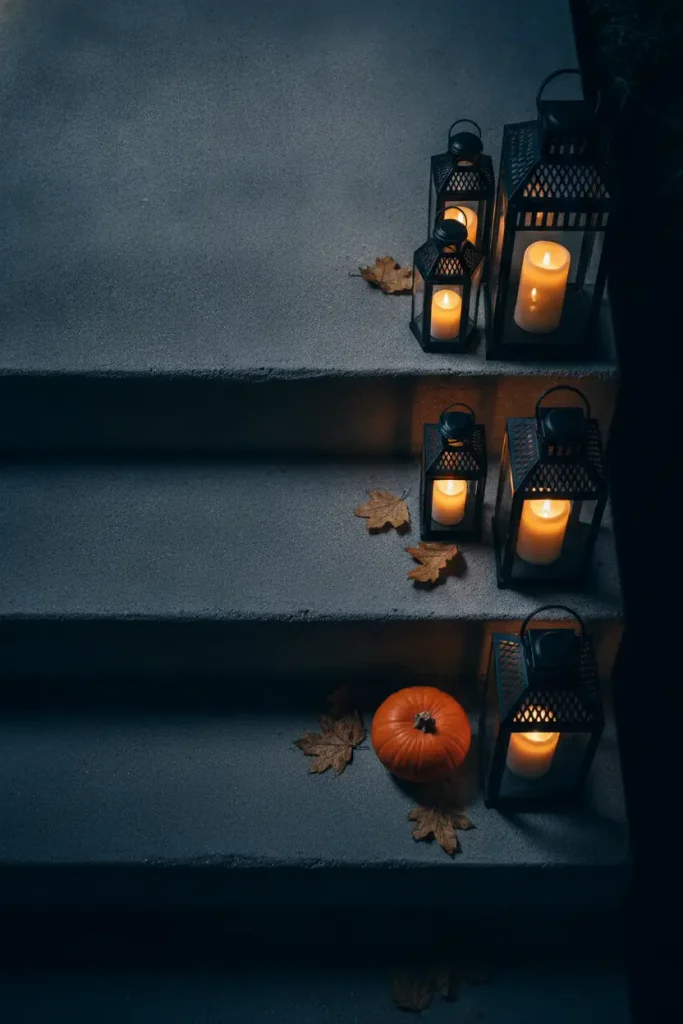 Cluster of lanterns with battery candles lighting concrete porch steps at night