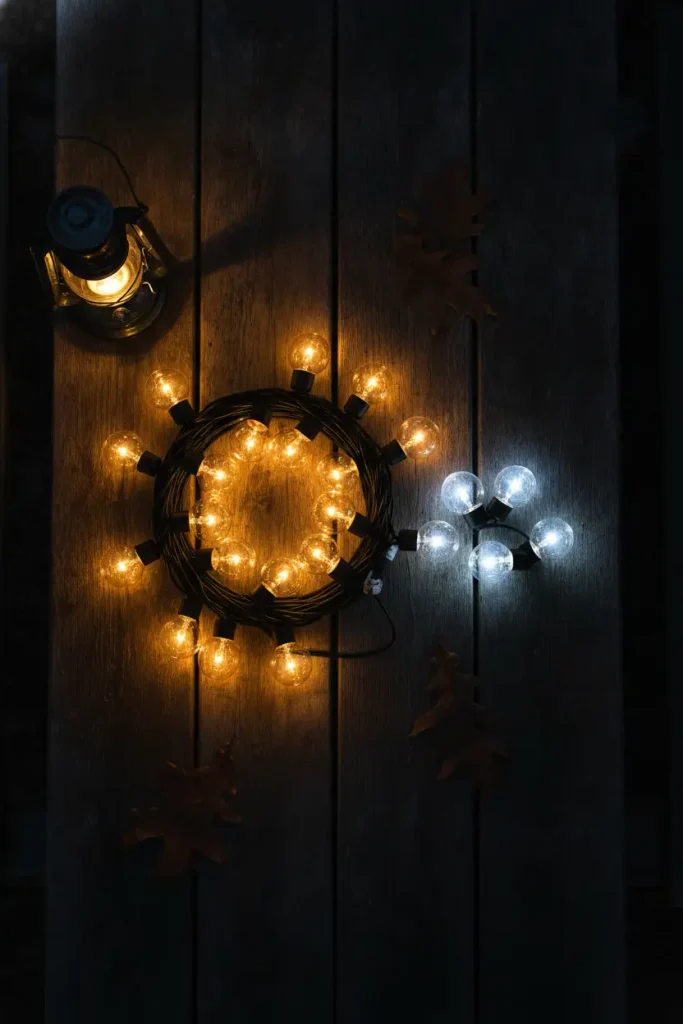Warm and cool white outdoor string light bulbs compared on a wood table at night